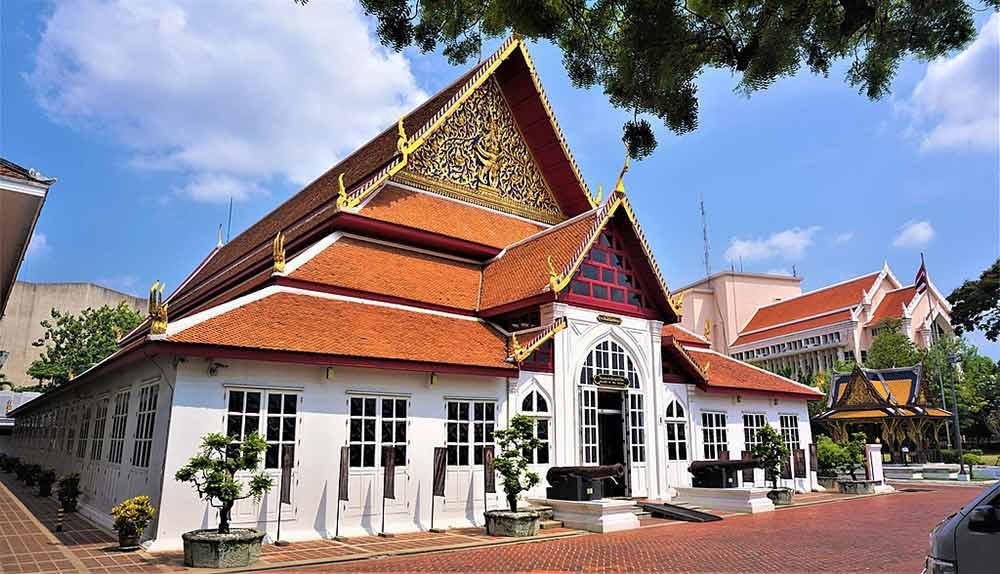 brown roof and white building known as the bangkok national museum