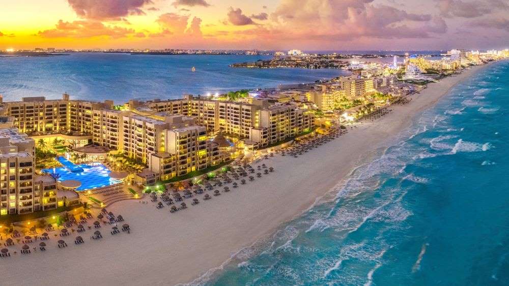 aerial view showing buildings light up near the beach -Best Time to Visit Cancun