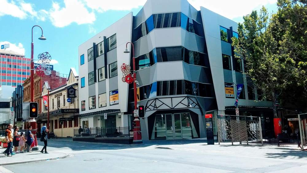 grey structure building near the road with people walking - australia digital nomad visa