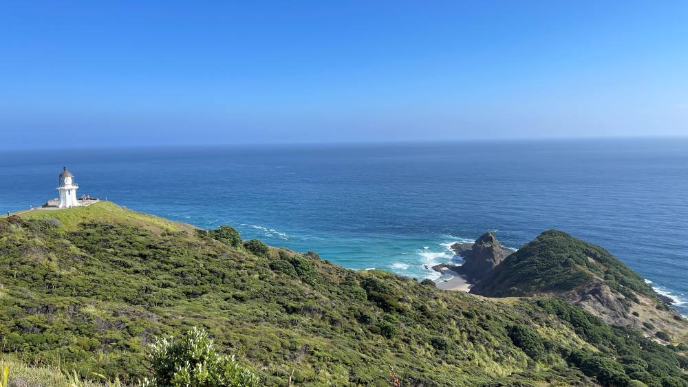 ocean view with the white lighthouse at the hill
