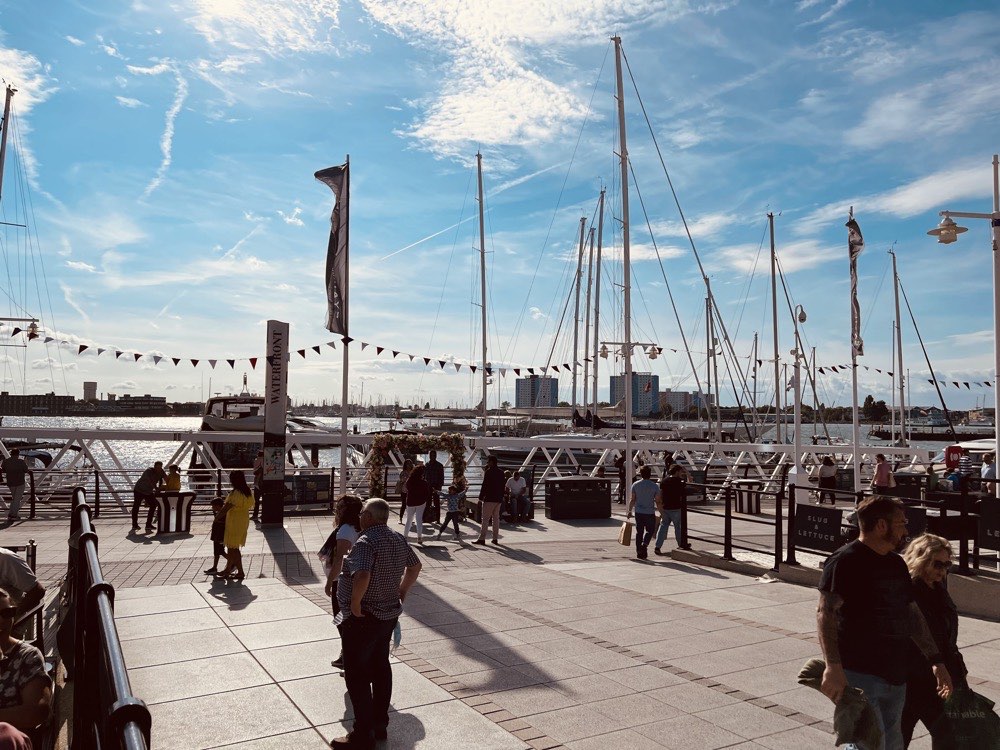 people walking around the port near body of water