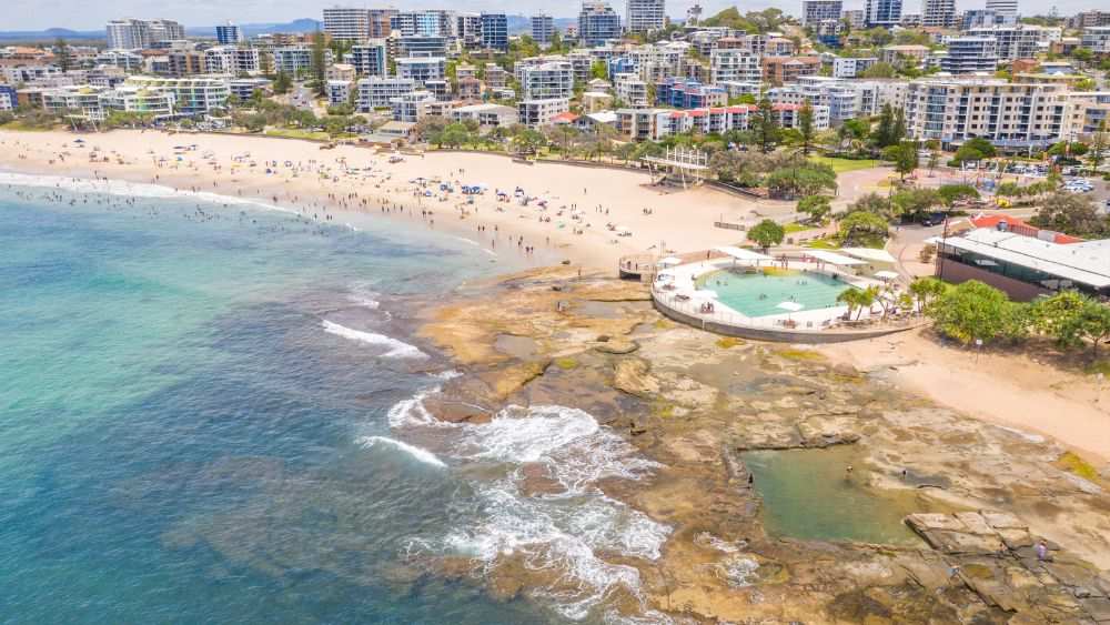 aerial view of a city with high rise building in front of the ocean