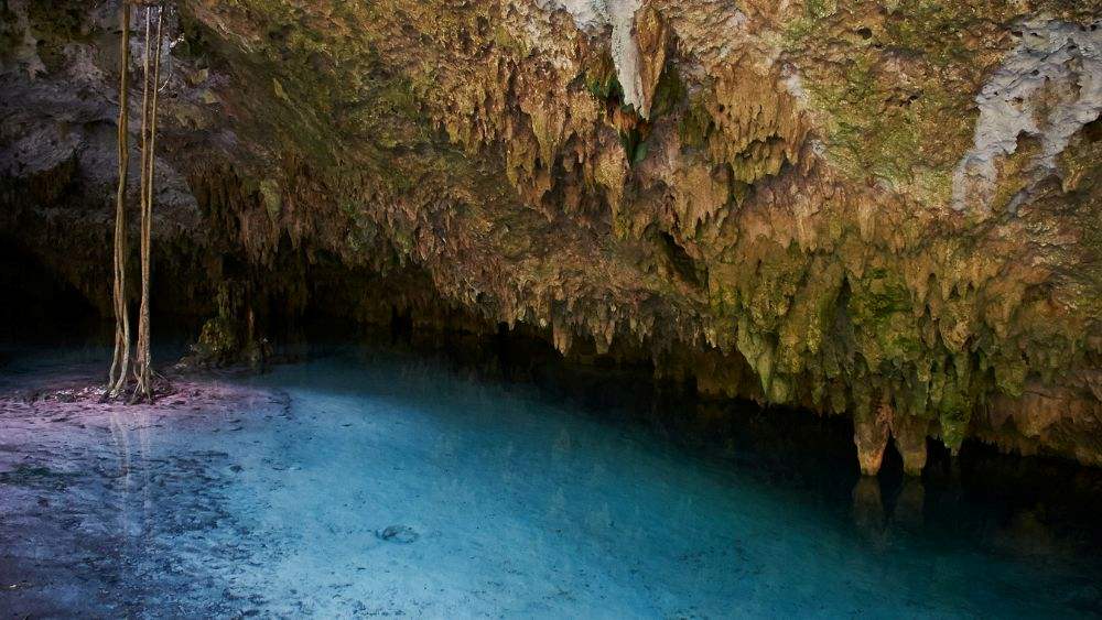 clear blue water near a rock formation cave