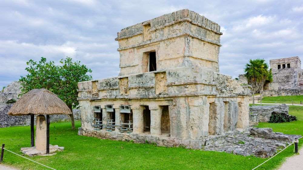 old rock structure building surrounded by green grass and some trees
