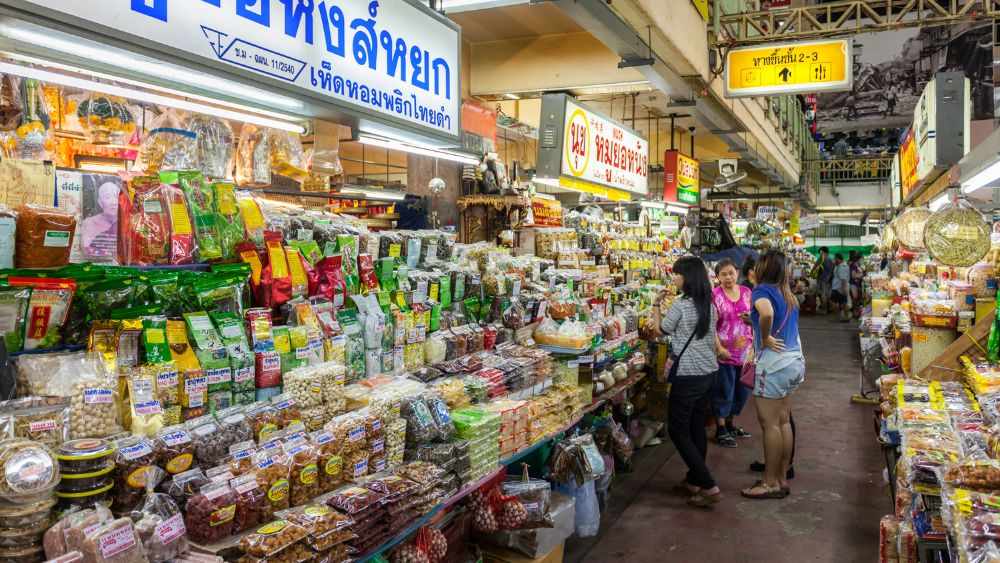 woman chatting in market with variety of display product