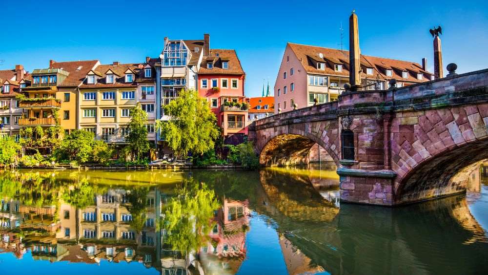 colorful old houses near the bridge and body of water - Oldest Cities in Europe to Visit in 2025