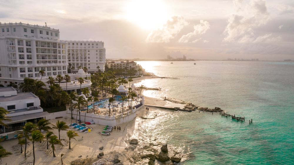aerial view of a white building that is a hotel resort near the beach